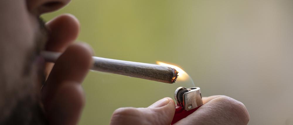 Ein Mann zündet sich einen Joint an.