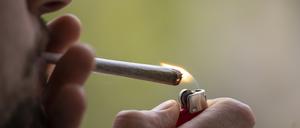 Ein Mann zündet sich einen Joint an.