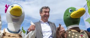 Markus Söder (CSU), Ministerpräsident von Bayern, steht während der Eröffnung der Bayerischen Landesgartenschau Kirchheim 2024 zwischen den Maskottchen „Stetti“ (links) und „Kirk“.
