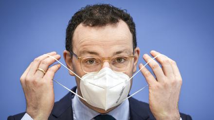 Der damalige Gesundheitsminister Jens Spahn (CDU) nimmt im Januar 2021 zu Beginn einer Pressekonferenz seine Maske ab.