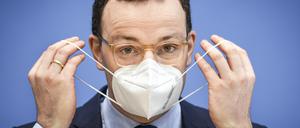 Der damalige Gesundheitsminister Jens Spahn (CDU) nimmt im Januar 2021 zu Beginn einer Pressekonferenz seine Maske ab.