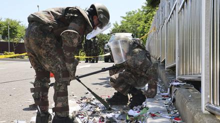 Südkoreanische Soldaten in Schutzkleidung überprüfen Müll eines vermutlich aus Nordkorea entsandten Ballons.