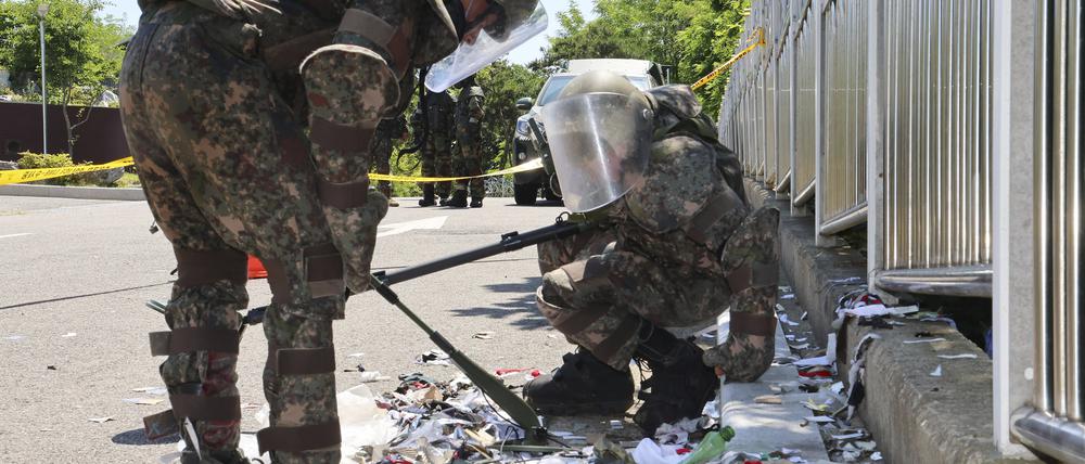Südkoreanische Soldaten in Schutzkleidung überprüfen Müll eines vermutlich aus Nordkorea entsandten Ballons.