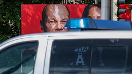 Ein Streifenwagen der sächsischen Polizei fährt an einem Wahlplakat der SPD mit dem Foto von Bundeskanzler Scholz vorbei (Symbolbild).