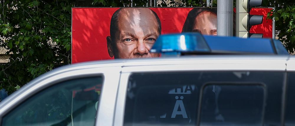 Ein Streifenwagen der sächsischen Polizei fährt an einem Wahlplakat der SPD mit dem Foto von Bundeskanzler Scholz vorbei (Symbolbild).