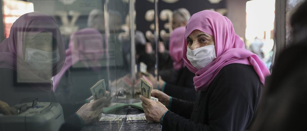 Eine Frau hält US-Dollarnoten in der Hand, während sie in einer Wechselstube türkische Lira wechselt.