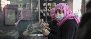 Eine Frau hält US-Dollarnoten in der Hand, während sie in einer Wechselstube türkische Lira wechselt.
