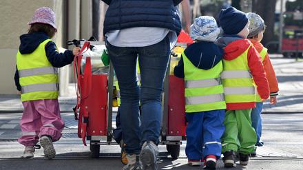 ARCHIV - 17.04.2018, Bayern, München: ILLUSTRATION - Ein Betreuerin läuft mit mehreren Kleinkindern über einen Bürgersteig . (zu dpa: «Ver.di ruft Erzieher in kommunalen Berliner Kitas zum Warnstreik auf») Foto: dpa +++ dpa-Bildfunk +++