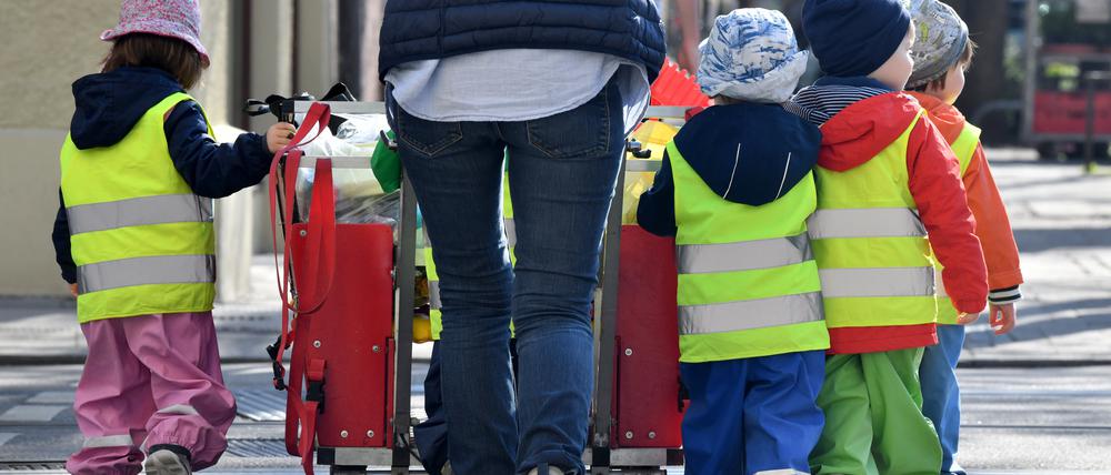ARCHIV - 17.04.2018, Bayern, München: ILLUSTRATION - Ein Betreuerin läuft mit mehreren Kleinkindern über einen Bürgersteig . (zu dpa: «Ver.di ruft Erzieher in kommunalen Berliner Kitas zum Warnstreik auf») Foto: dpa +++ dpa-Bildfunk +++