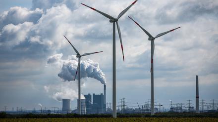 Windräder drehen sich vor der Kulisse des Braunkohlekraftwerks Schkopau westlich von Halle (Saale).