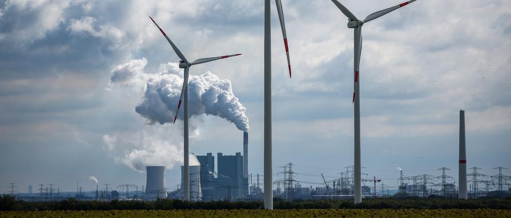 Windräder drehen sich vor der Kulisse des Braunkohlekraftwerks Schkopau westlich von Halle (Saale).
