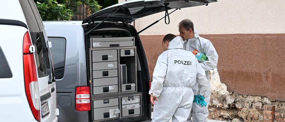 Spurensicherer der Polizei stehen an ihrem Auto. Sie untersuchen einen Fundort von zwei Leichen, die nach einem Unwetter in einem Keller gefunden worden waren.