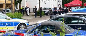 Einsatzkräfte der Polizei stehen vor einem Mehrfamilienhaus im Stadtteil Milbertshofen. 