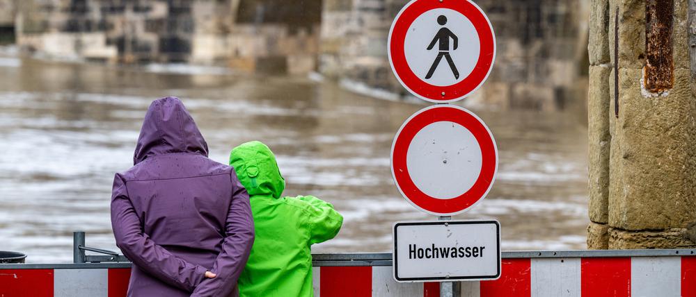 Ein Schild warnt an der Steinernen Brücke vor dem Hochwasser der Donau.