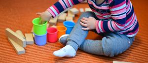 ARCHIV - 20.10.2017, Baden-Württemberg;Thüringen, ---: Ein Mädchen spielt in einer Kita mit bunten Bechern und Bauklötzen. (zu dpa: «Kitas, Klima und Kliniken: Vor diesen Problemen stehen die Kommunen») Foto: Uwe Anspach/dpa +++ dpa-Bildfunk +++