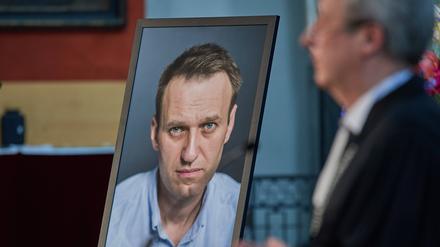 Landesbischof Christian Stäblein spricht neben einem Bild von Alexej Nawalny.