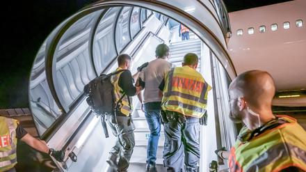 Polizeibeamte begleiten 2019 einen Afghanen auf dem Flughafen Leipzig-Halle in ein Charterflugzeug.