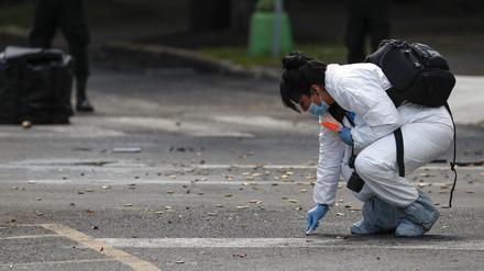 Eine Mitarbeiterin der Forensik kniet neben zahlreichen Patronen nach einem Attentat gegen den Polizei-Chef von Mexiko-Stadt. 