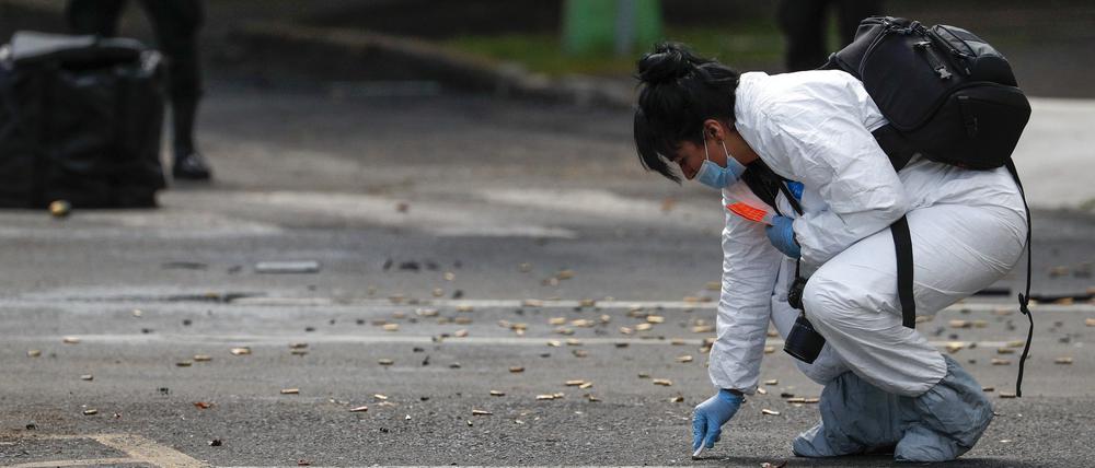 Eine Mitarbeiterin der Forensik kniet neben zahlreichen Patronen nach einem Attentat gegen den Polizei-Chef von Mexiko-Stadt. 
