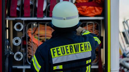 Ein Feuerwehrmann holt Equipment aus einem Einsatzfahrzeug an der Feuerwache der Feuerwehr. 