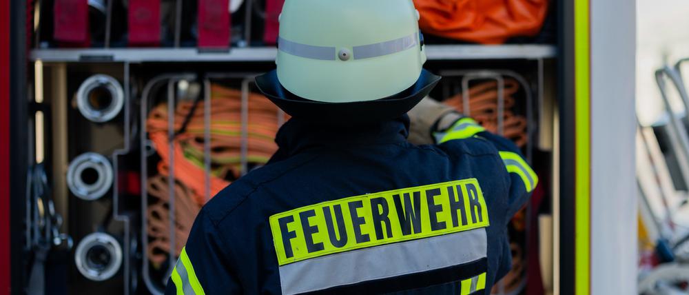 Ein Feuerwehrmann holt Equipment aus einem Einsatzfahrzeug an der Feuerwache der Feuerwehr.
