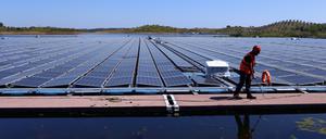 Ein Arbeiter ist bei der Installation des größten schwimmenden Solarparks von EDP (Energias de Portugal) auf einem Staudamm in Europa zu sehen.