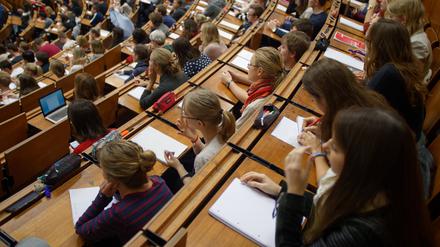 Studenten und Studentinnen der Georg-August-Universität in Göttingen sitzen im Zentralen Hörsaalgebäude (ZHG) und verfolgen eine Vorlesung.