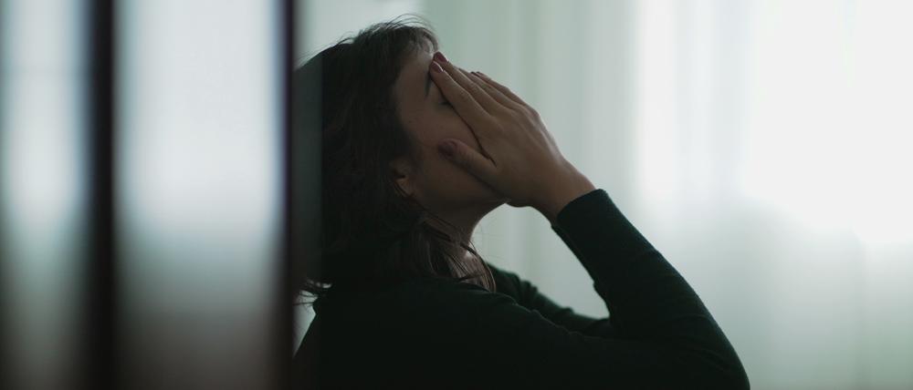 Eine verzweifelte Frau hat die Hände vors Gesicht geschlagen
