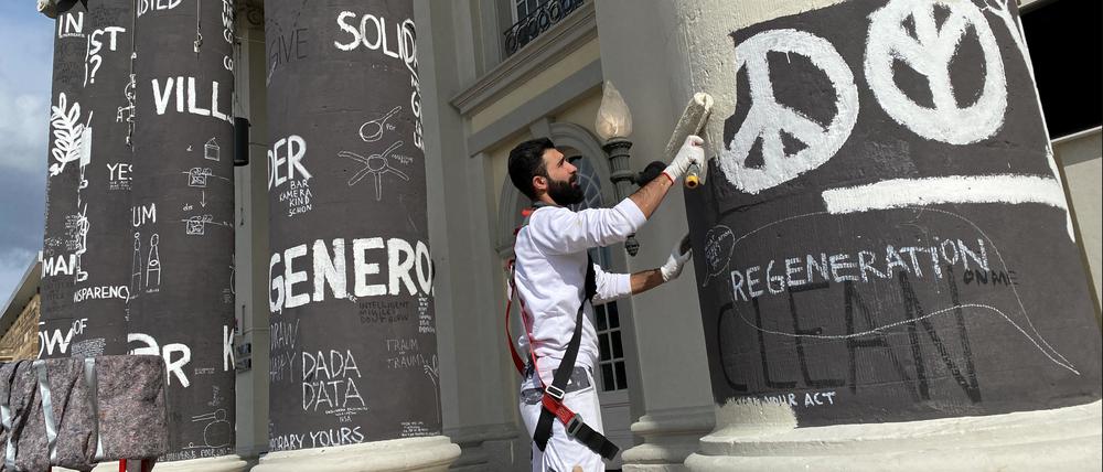 Das Ende der Documenta fifteen: Am Tag danach übermalt ein Mitarbeiter einer Malerfirma die Säulen des Fridericianums, die der rumänische documenta-Teilnehmer Dan Perjovschi mit Botschaften und Illustrationen bemalt hatte.