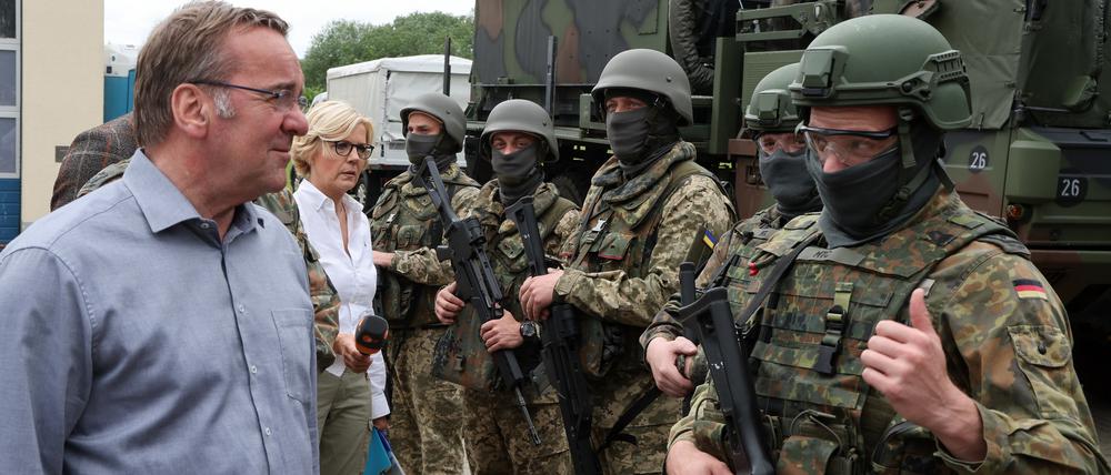 Boris Pistorius (SPD, l), Bundesverteidigungsminister, informiert sich bei einem Besuch der Flugabwehrraketengruppe 21 auf einem Truppenübungsplatz in Mecklenburg-Vorpommern über die Ausbildung ukrainischer Soldaten an dem bodengebundenen Luftverteidigungssystem Patriot und spricht dabei mit einem Soldaten der Bundeswehr (r). 