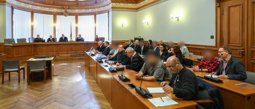 Mehrere Angeklagte einer syrischen Familie sitzen mit ihren Verteidigern und Dolmetschern im Prozess um die Entführung eines angeblichen Voodoo-Zauberers im Landgericht Leipzig.