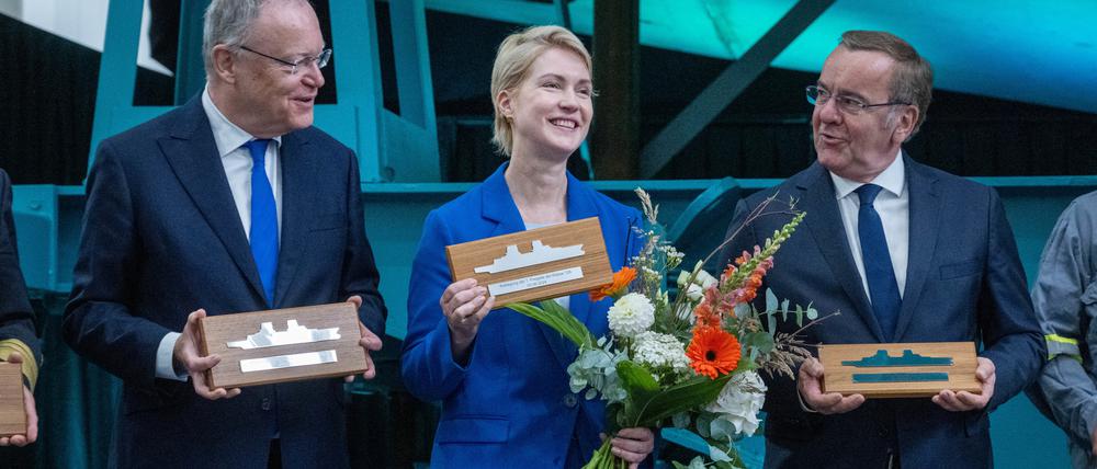 Boris Pistorius (SPD, r.), Bundesverteidigungsminister, Manuela Schwesig (SPD, M.), Mecklenburg-Vorpommerns Ministerpräsidentin, und Stephan Weil (SPD, l.), Niedersachsens Ministerpräsident, halten bei der Kiellegung der Fregatte F126 „Niedersachsen“ auf dem Werftgelände der zur Lürssen-Werftengruppe gehörenden Peene-Werft Erinnerungsplaketten in der Hand.