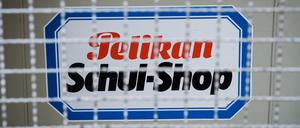 Ein Aufkleber mit der Aufschrift „Pelikan Schul-Shop“ klebt am an der vergitterten Eingangstür eines alten Schreibwarengeschäftes.