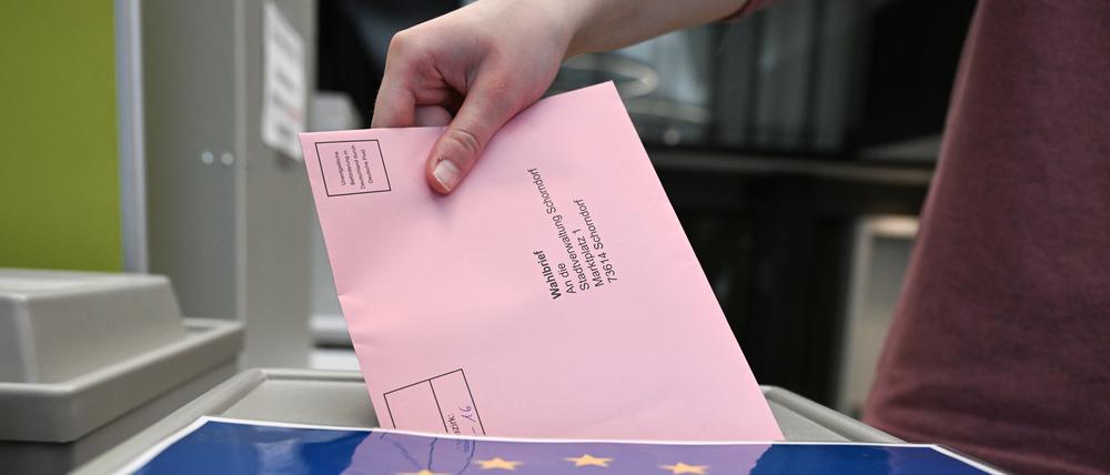 Ein Wahlbrief mit einem Stimmzettel für die Europawahl wird im Rathaus in einem Wahllokal für die Briefwahl in eine Wahlurne gesteckt.