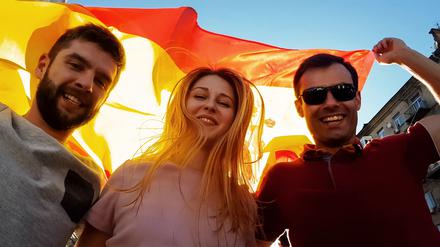 Happy young people celebrating victory of national Spanish team, sport tourism