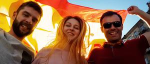 Happy young people celebrating victory of national Spanish team, sport tourism