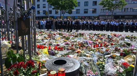 Blumen und Kerzen liegen bei einer Gedenkminute auf dem Marktplatz in Mannheim zum Gedenken an einen getöteten Polizisten.