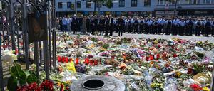 Blumen und Kerzen liegen bei einer Gedenkminute auf dem Marktplatz in Mannheim zum Gedenken an einen getöteten Polizisten.