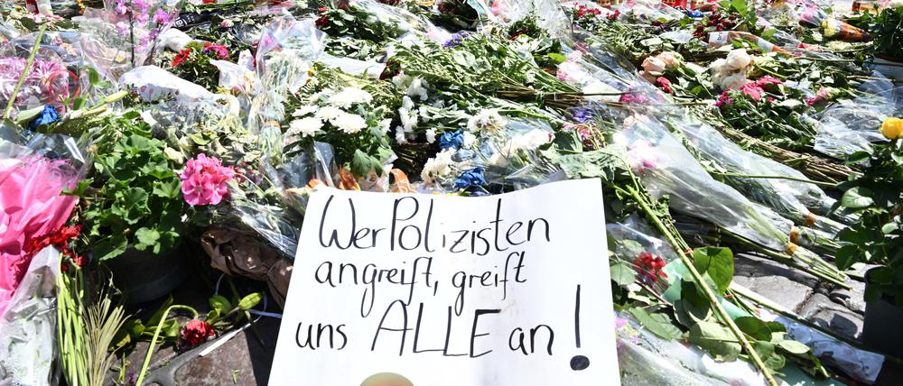 Blumen und Kerzen liegen bei einer Gedenkminute auf dem Marktplatz in Mannheim zum Gedenken an einen getöteten Polizisten. 