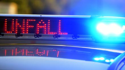 Auf einem Polizeifahrzeug warnt eine Leuchtschrift vor einer Unfallstelle.