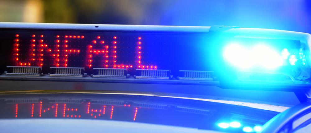 Auf einem Polizeifahrzeug warnt eine Leuchtschrift vor einer Unfallstelle.
