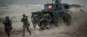 29.05.2024, Litauen, Pabrade: Soldaten der Bundeswehr springen zum Abschluss bei der Nato-Übung Quadriga 2024 aus einem Puma-Schützenpanzer.