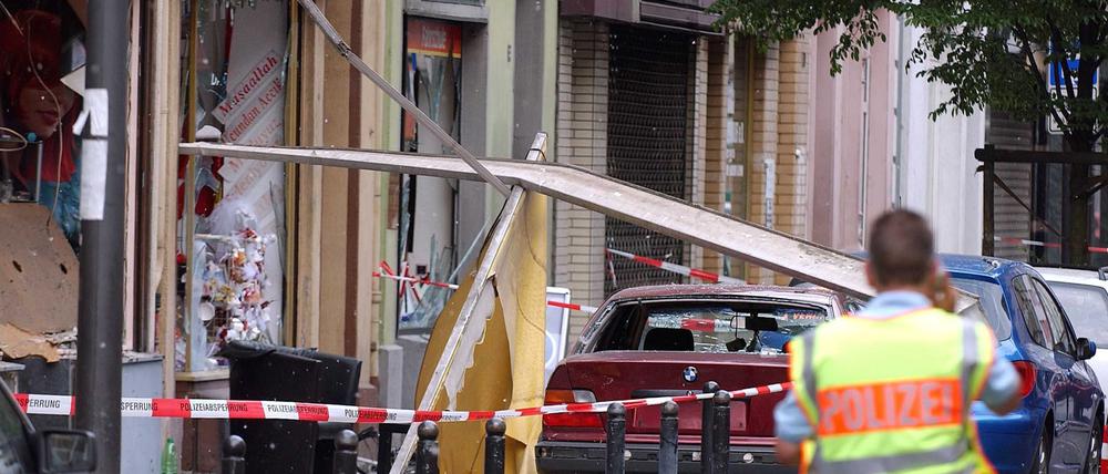 Ein Polizist sichert die Spuren einer Explosion in der Keupstraße. Am 9. Juni 2004 hatten NSU-Mitglieder vor einem Friseursalon eine Nagelbombe gezündet. 22 Menschen wurden verletzt, vier davon schwer. 