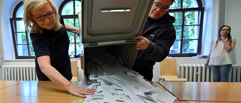 Wahlhelfer schütten die Wahlurne aus bei der Stichwahl und der Europawahl in einem Wahllokal in der Landeshauptstadt Thüringen. 