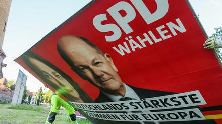 Zwei Mitarbeiter einer Firma für Werbeaufsteller bauen ein Wahlplakat der Partei „SPD“ mit einem Foto von Bundeskanzler Scholz und der Spitzenkandidatin Barley nach der Europawahl ab. (Symbolbild)