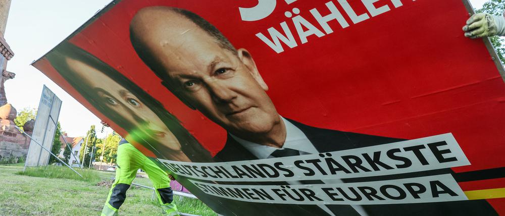 Zwei Mitarbeiter einer Firma für Werbeaufsteller bauen ein Wahlplakat der Partei „SPD“ mit einem Foto von Bundeskanzler Scholz und der Spitzenkandidatin Barley nach der Europawahl ab. (Symbolbild)