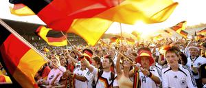 Deutsche Fans schwenken ihre Landesfahnen bei der WM 2006 beim Public Viewing in der Glück Auf Kampfbahn in Gelsenkirchen.