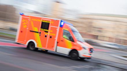 Ein Rettungswagen der Feuerwehr fährt mit Blaulicht durch die Innenstadt. (Symbolbild)