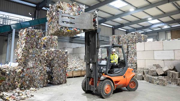 Ein Mitarbeiter hebt mit einem Gabelstapler in Ballen gepressten Aluminiumabfall aus der Gelben Tonne in einer Halle des neuen Werk II der Recyclingfirma PreZero Pyral.