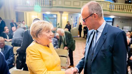 Angela Merkel (CDU), ehemalige Bundeskanzlerin, und Friedrich Merz, CDU-Bundesvorsitzender, begrüßen sich bei der Eröffnungsveranstaltung der Bundeskanzler-Helmut-Kohl-Stiftung in der Friedrichstadtkirche am Gendarmenmarkt (Archivbild).